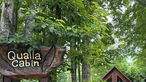 Uma cabana rústica chamada Qualla Cabin, em Catawba Ridge, rodeada por vegetação densa.