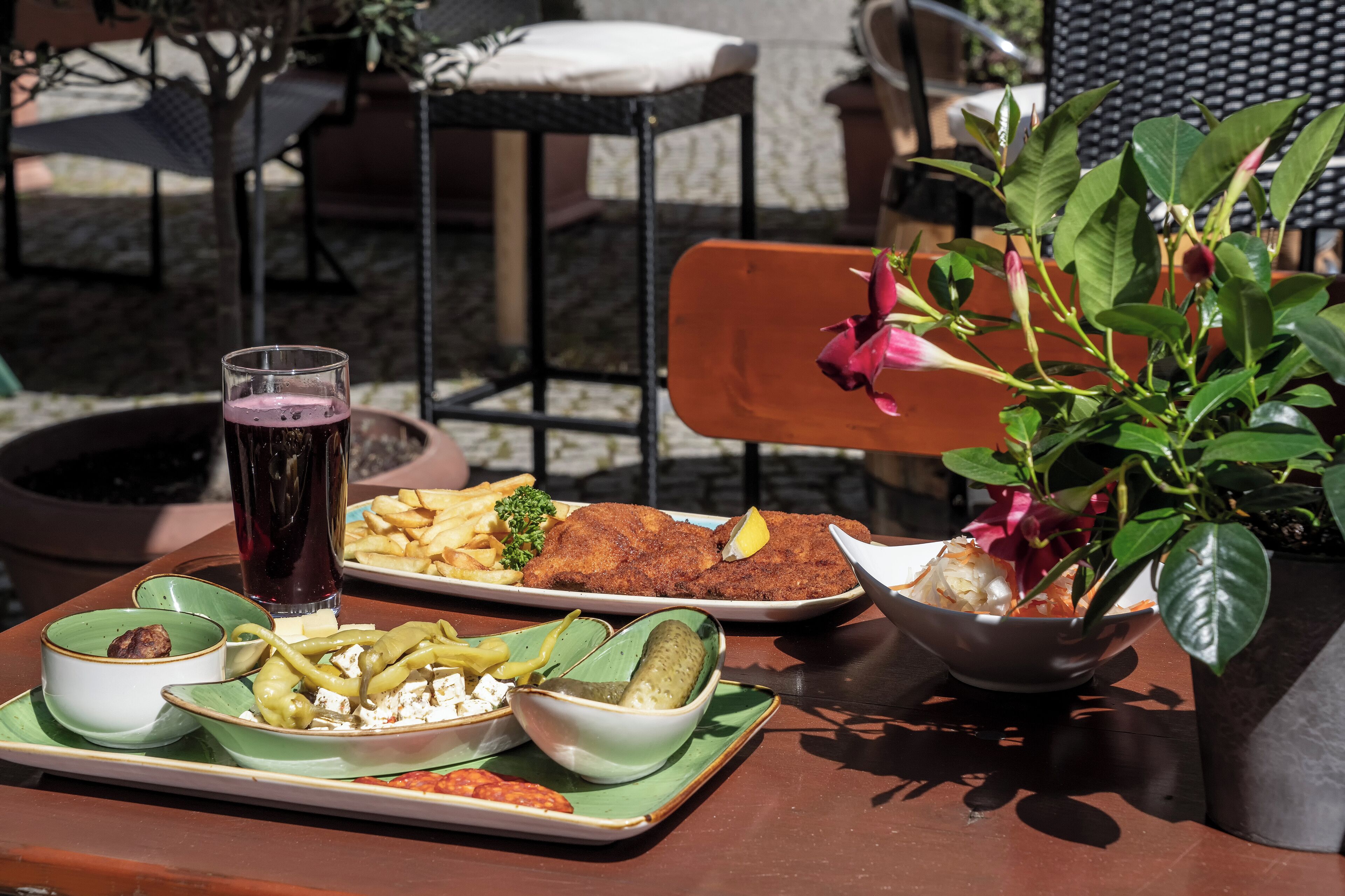 Uma mesa com diversos pratos, incluindo peixe à milanesa, batatas fritas e uma salada.