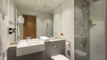 Ein modernes Badezimmer mit einer Duschkabine aus Glas, einem Waschbecken und einer Toilette.
