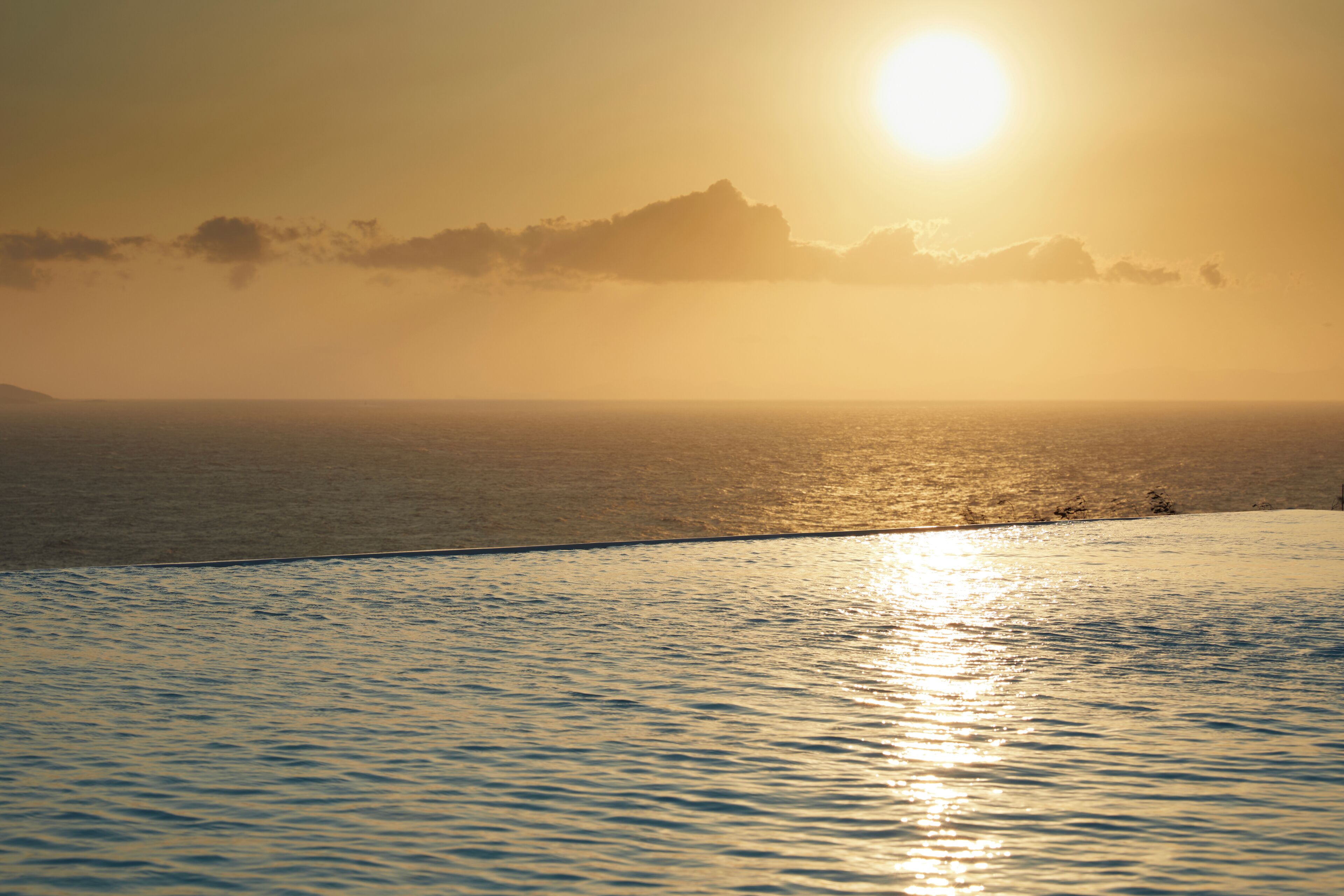 Un atardecer sobre un mar tranquilo con horizonte despejado.
