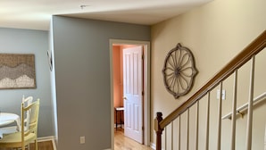 A hallway with a dining area, a staircase, and a door leading to another room. - 4BR 3.5BA POOL - Walk or bike to town and beach! (Rehoboth Beach)