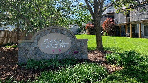 A stone sign with "CANAL LANDING" written on it, surrounded by greenery and a well-maintained lawn. - 4BR 3.5BA POOL - Walk or bike to town and beach! (Rehoboth Beach)