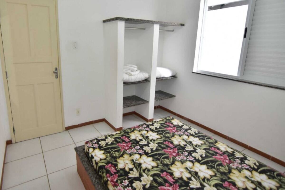 A bedroom with a bed, a wardrobe, a window, and a door.