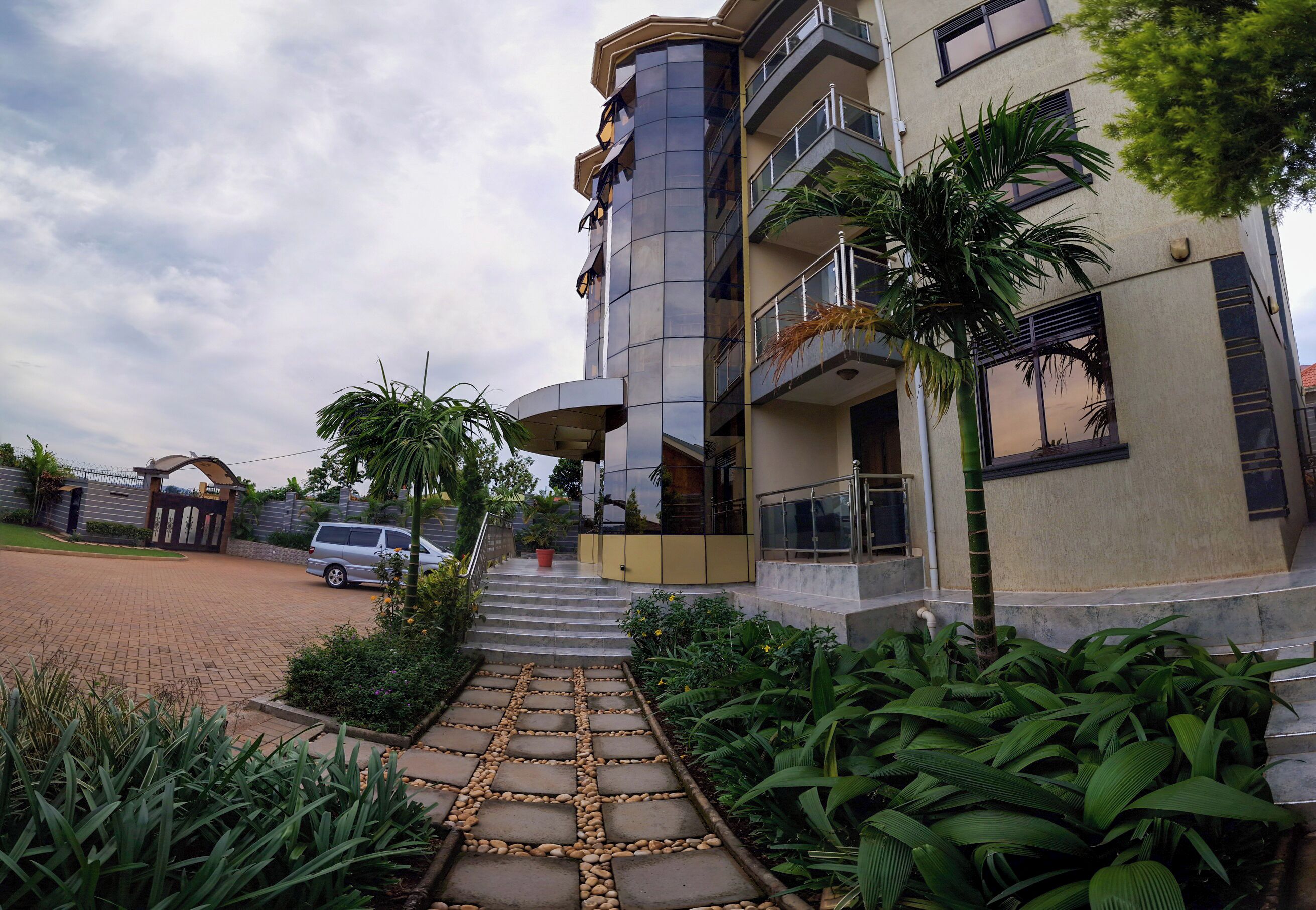 Un edificio de varios pisos con un diseño moderno, que presenta una escalera central que conduce a la entrada.