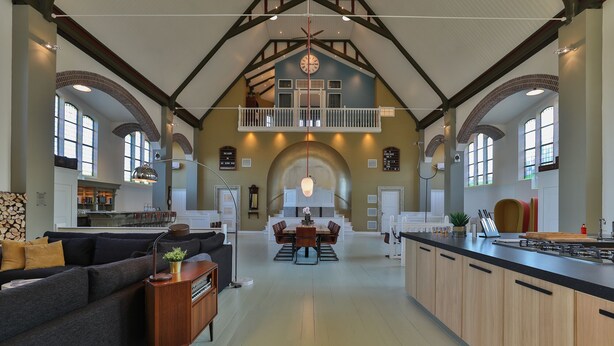 A spacious kitchen with a central island, a dining area with a high ceiling and exposed beams, and a cozy seating area with a sofa and a small side table. - Church conversion for a unique stay and experience: 5 bedrooms and 5 bathrooms (Rinsumageest)