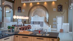 A spacious kitchen with a large island, wooden cabinets, and a second-story balcony. - Church conversion for a unique stay and experience: 5 bedrooms and 5 bathrooms (Rinsumageest)