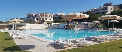 حمّام سباحة خارجي موسمي، مظلات على حمّام السباحة، مقاعد للتشمس