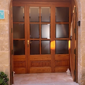 A wooden double door with glass panels and a small sign above it.