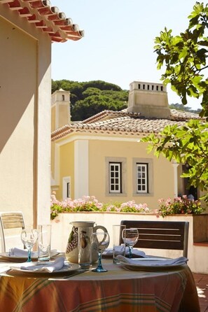 A table set outdoors with a view of a building with a tiled roof and windows.