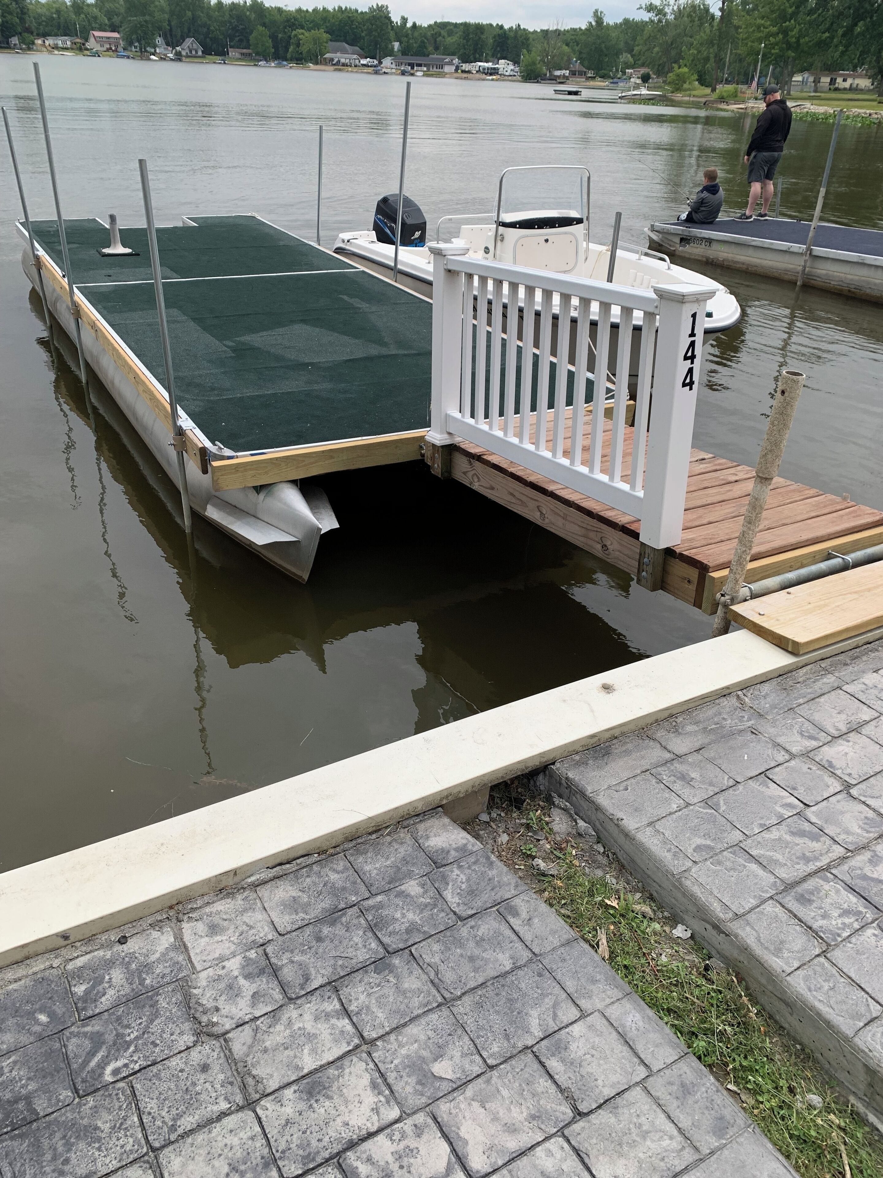 Un muelle con una plataforma verde y barandilla blanca.