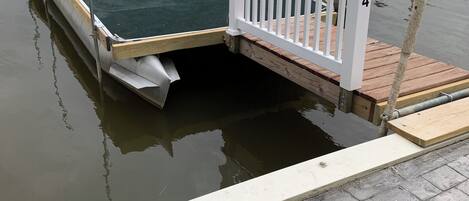 Un muelle con una plataforma verde y barandilla blanca.