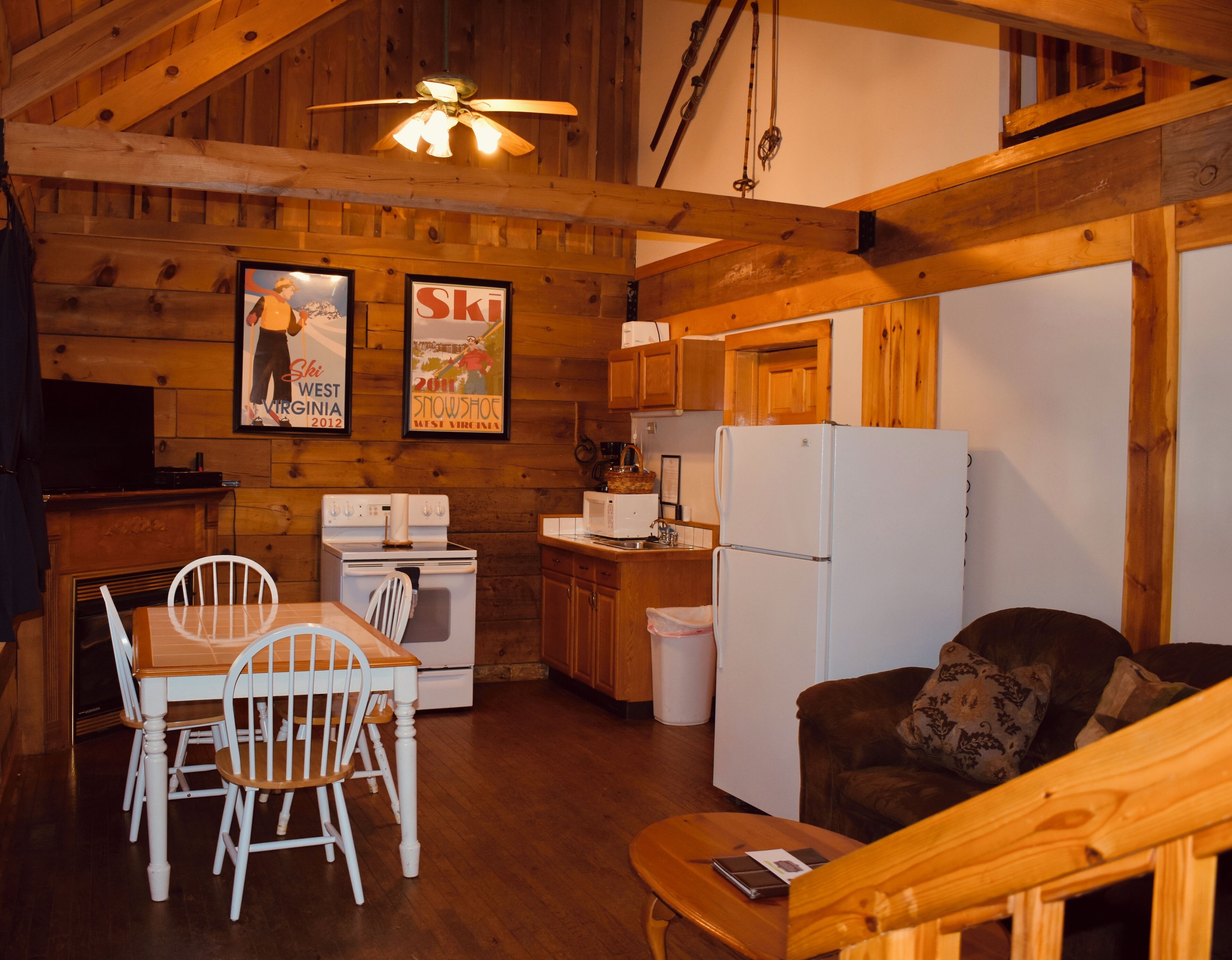A cozy cabin interior with a dining area, kitchen, and seating space.