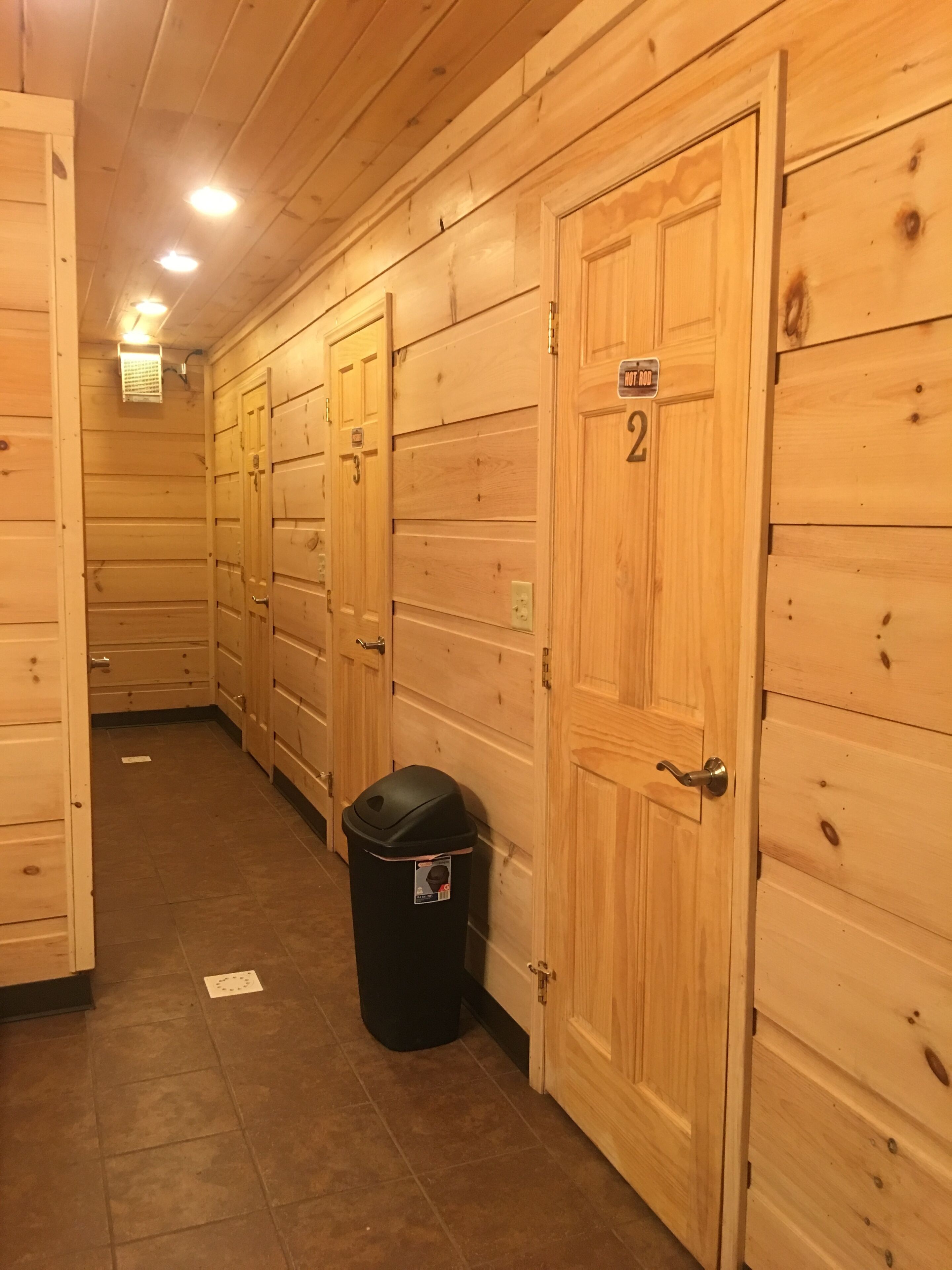A hallway with wooden panel walls and doors numbered 2, 3, and 4.