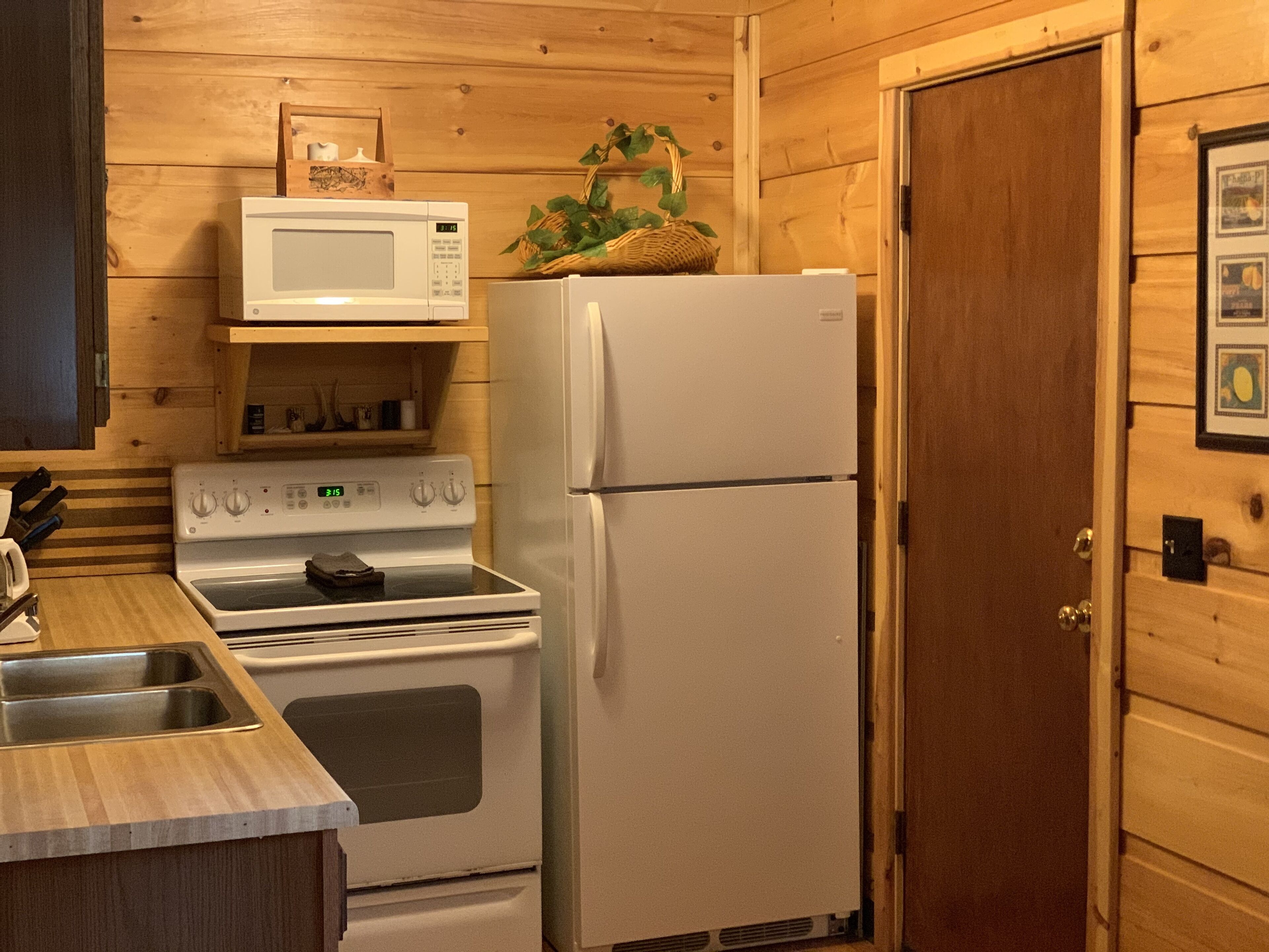 A compact kitchen with a microwave, stove, and refrigerator.