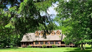 A lodge with a large porch, multiple windows, and a covered deck area. - Elk Springs Resort (Monterville)