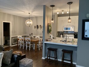 A modern kitchen with white cabinets, a central island, and pendant lighting. - Relaxing & Family-Friendly, lakeside condo w/ pool & balcony. (Pottsboro)