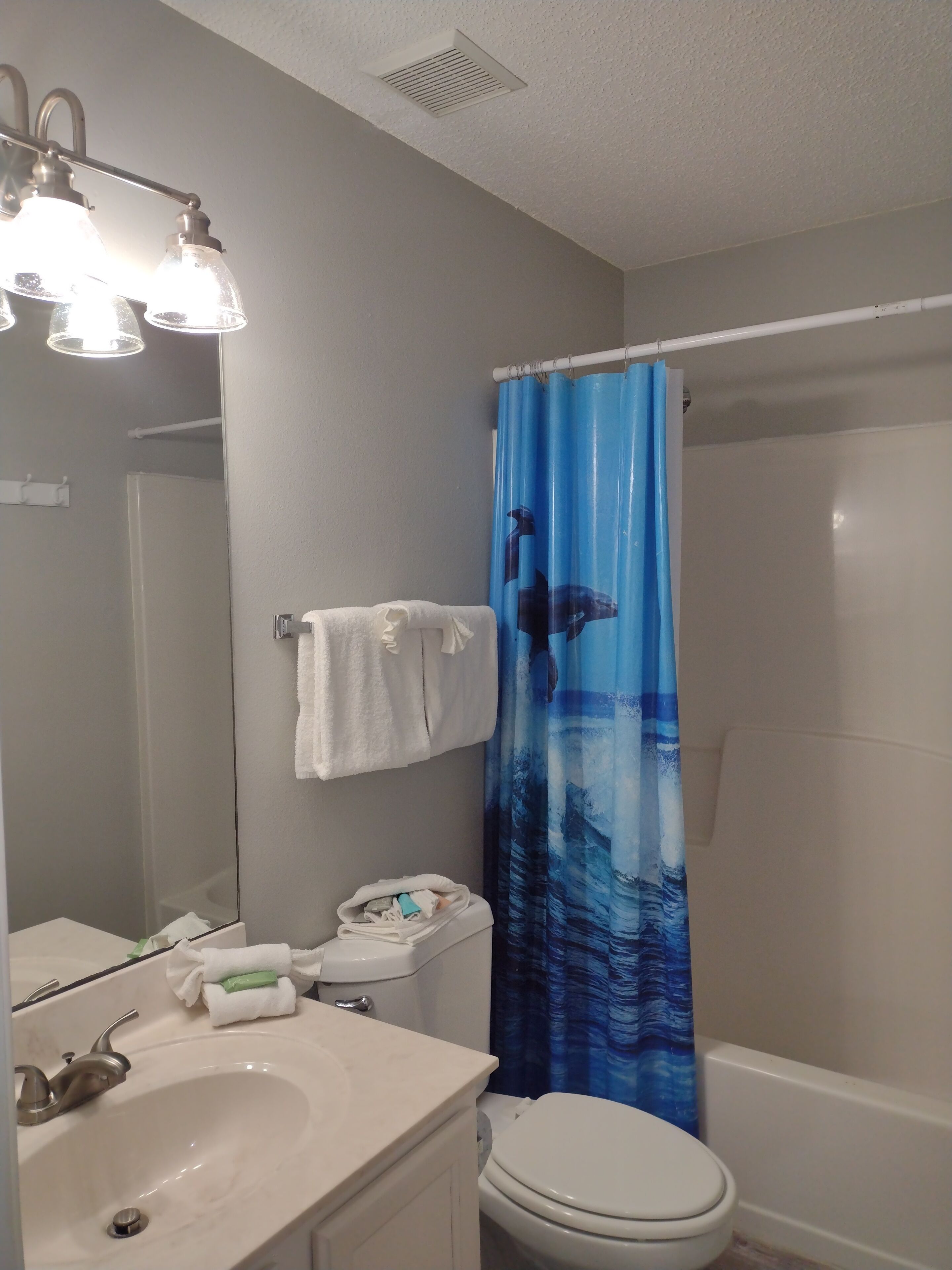 Ein Badezimmer mit Waschbecken, Toilette und Duschvorhang.