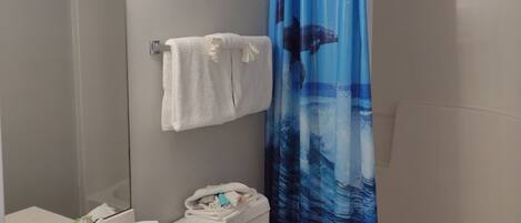 A bathroom with a sink, toilet, and shower curtain.