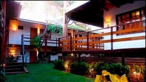 A building with a wooden balcony, a staircase, and a well-maintained lawn. - All Blue (Jijoca de Jericoacoara)