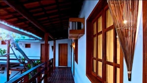 A covered wooden walkway leading to a building with large windows and a traditional bamboo lamp. - All Blue (Jijoca de Jericoacoara)