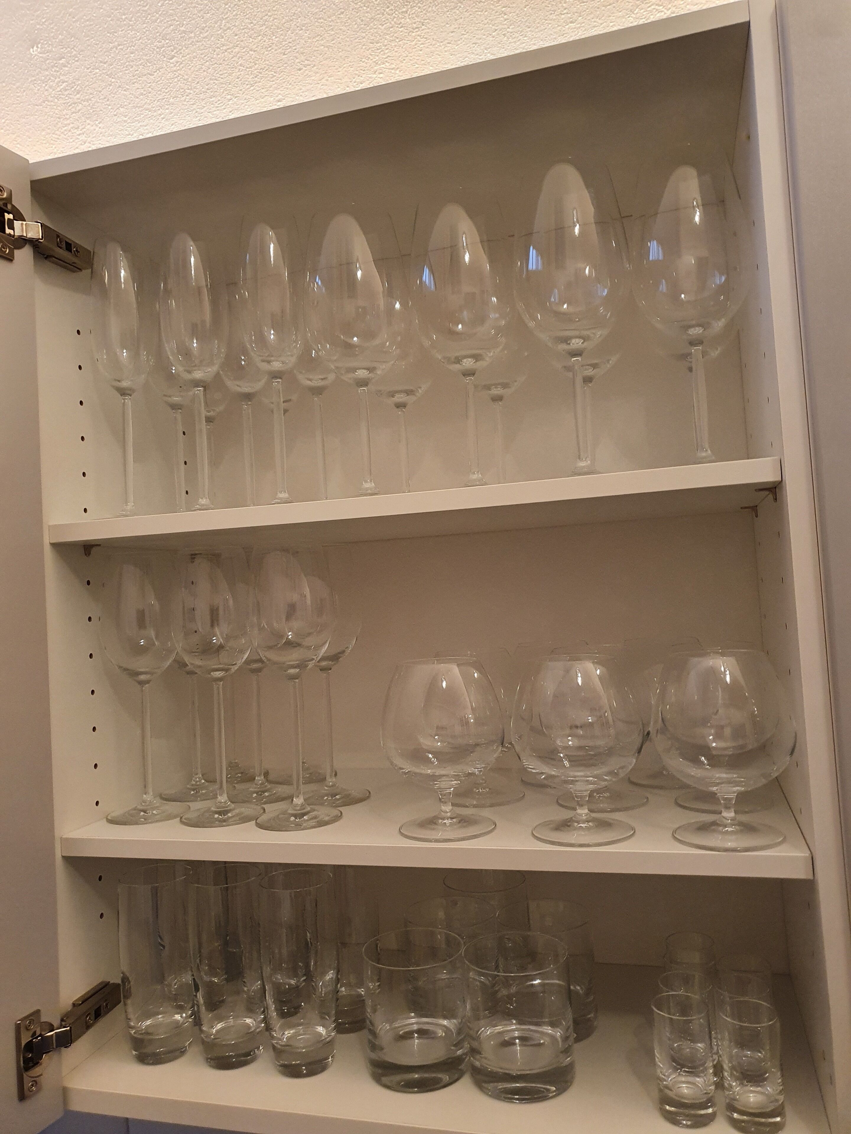 Une étagère avec différents types de verres à vin et de verres à eau.