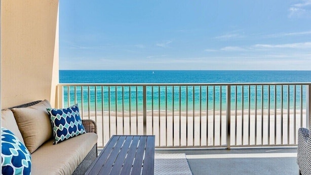 Un balcon avec vue sur une plage et l’océan.