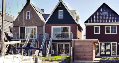 Maison moderne avec grande terrasse et jardin sur un canal et une jetée privés