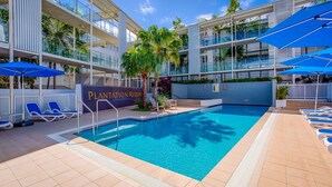 A pool area with lounge chairs and umbrellas at Plantation Resort.