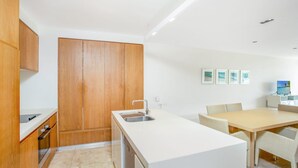 A modern kitchen with wooden cabinets, a white countertop, and a built-in dishwasher.