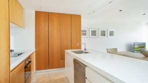 A modern kitchen with wooden cabinets, a white countertop, and a dishwasher. - Unit 101 Plantation Resort - Rainbow Beach. Plantation Resort. Second Floor. Aircon. Pool. Spa.Wifi (Rainbow Beach)