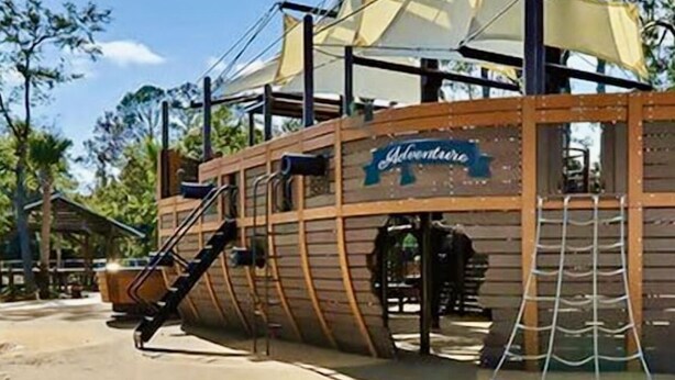 Un edificio con temática de barco pirata de madera, con un letrero que dice 'Adventurers'.