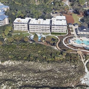 An aerial view of a hotel with multiple floors, a swimming pool, and landscaped gardens. - Newley Renovated 2 Bedroom Ocean Front Villa in South Forest Beach! (Hilton Head Island)