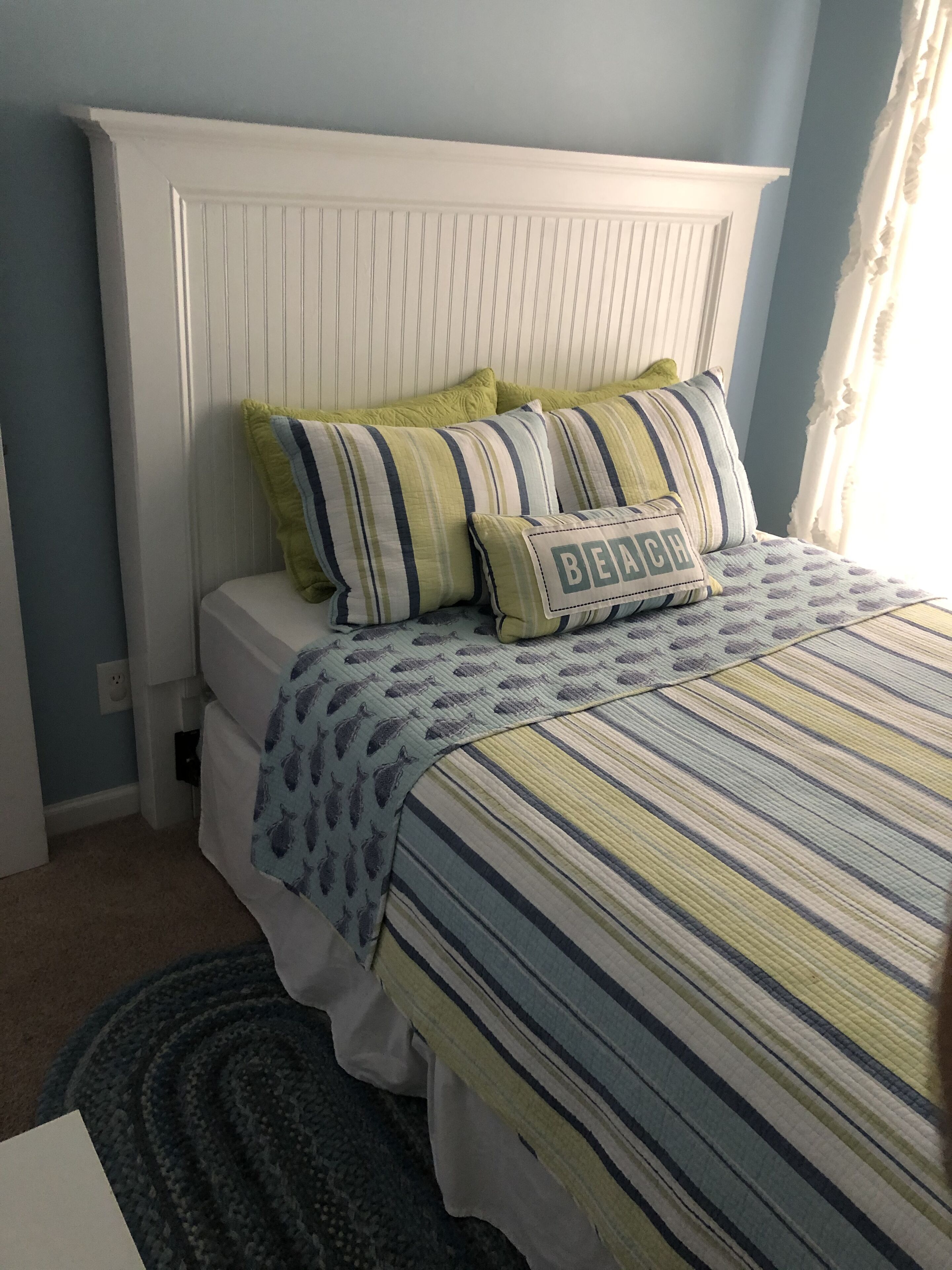 A bed with striped bedding, pillows, and a headboard.