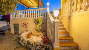A well-lit outdoor staircase with a decorative railing, leading to a covered area with string lights. - Wonderful private villa for 6 guests with A/C, private pool, WIFI, TV and terrace (Benissa)