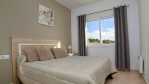 A bedroom with a bed, a window with curtains, a wall art piece, and a bedside table with a lamp. - Wonderful private villa for 6 guests with A/C, private pool, WIFI, TV and terrace (Benissa)