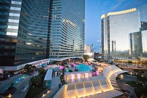 A modern hotel with a rooftop pool area, surrounded by high-rise buildings.