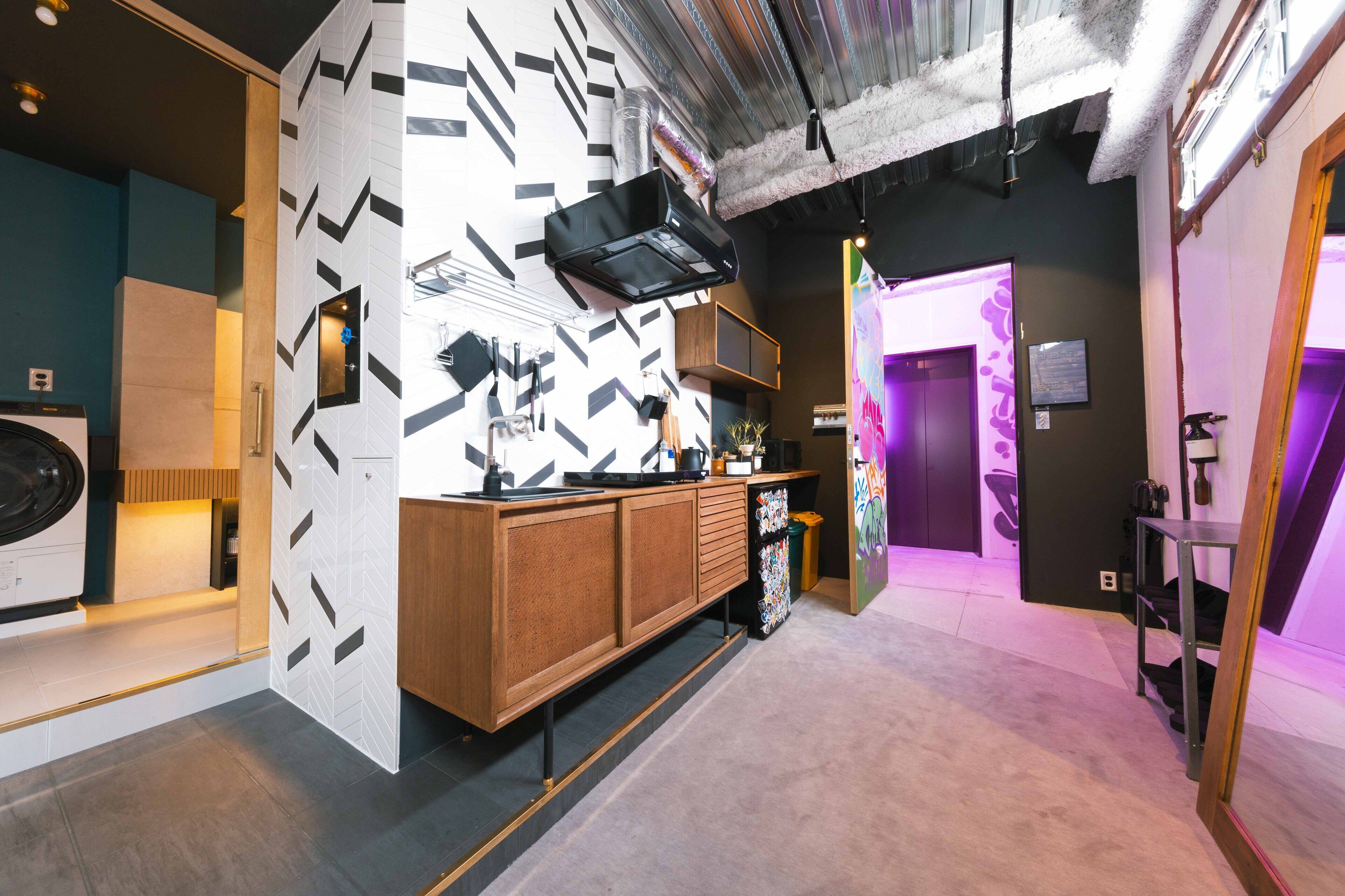 A modern kitchen with a wooden cabinet, a built-in microwave, and a black range hood.