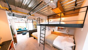 Una habitación compacta y moderna con literas, un escritorio y una zona de estar.