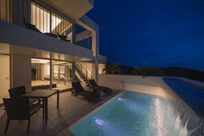 A modern house with a swimming pool, outdoor seating, and a staircase leading to a balcony. - Ken Ken Villa Yuumodoro (Motobu)