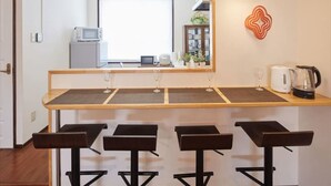 Cuina moderna amb zona de bar, equipada amb microones, bullidora i tamborets.