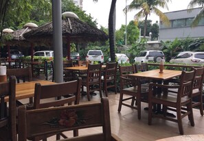 Enjoy a casual dining experience surrounded by lush greenery and tropical plants.