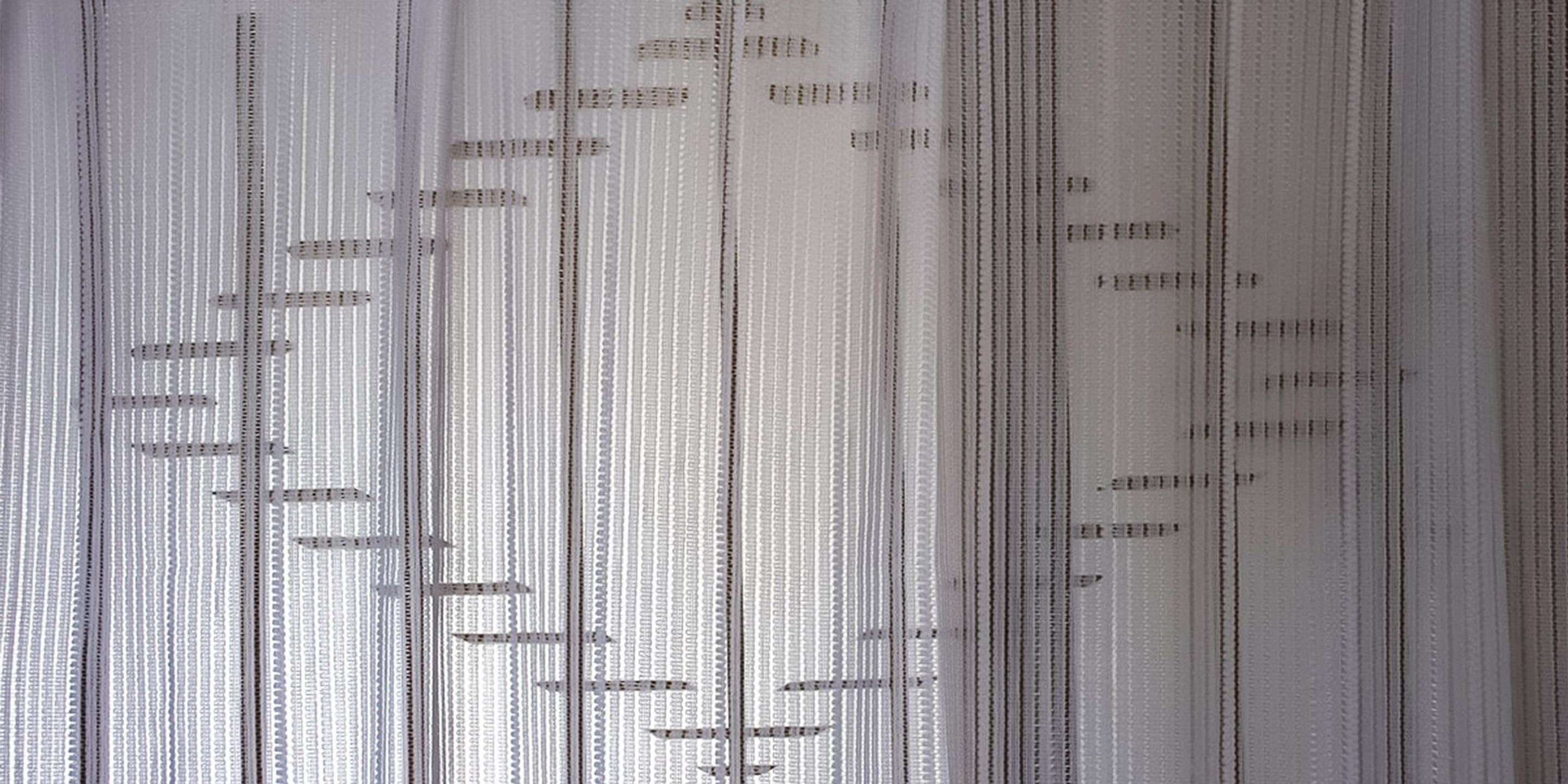 A close-up of a fabric with vertical lines and small rectangular patterns.