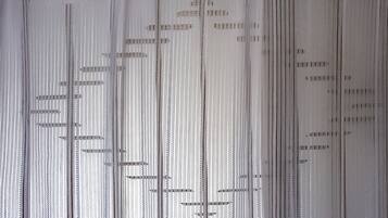 A close-up of a fabric with vertical lines and small rectangular patterns.