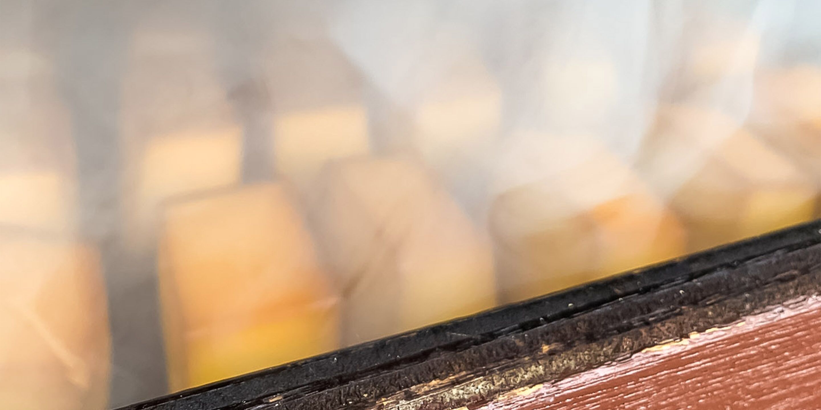 Een detail van een houten oppervlak met een zwarte rand, mogelijk onderdeel van een meubelstuk of een architectonisch element.