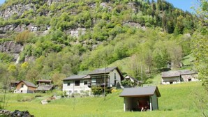 Eine Berglandschaft mit einer Ansammlung rustikaler Häuser, umgeben von üppigem Grün.