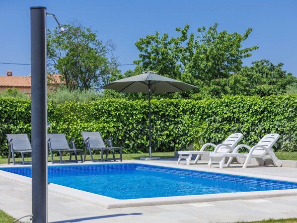 A swimming pool with lounge chairs and an umbrella. - Beautiful private villa for 6 guests with WIFI, A/C, private pool, TV and terrace (Porec)