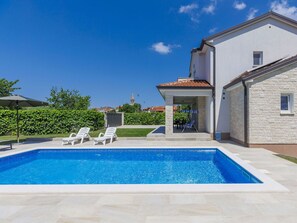 A swimming pool with lounge chairs, a covered patio, and a stone building with a tiled roof. - Beautiful private villa for 6 guests with WIFI, A/C, private pool, TV and terrace (Porec)