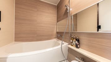 Uma casa de banho moderna com uma banheira independente, sanita e toucador com espelho.