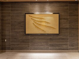 A wall with a framed golden wheat design.