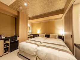 Habitación de hotel con una cama grande, un escritorio con computadora y un armario.